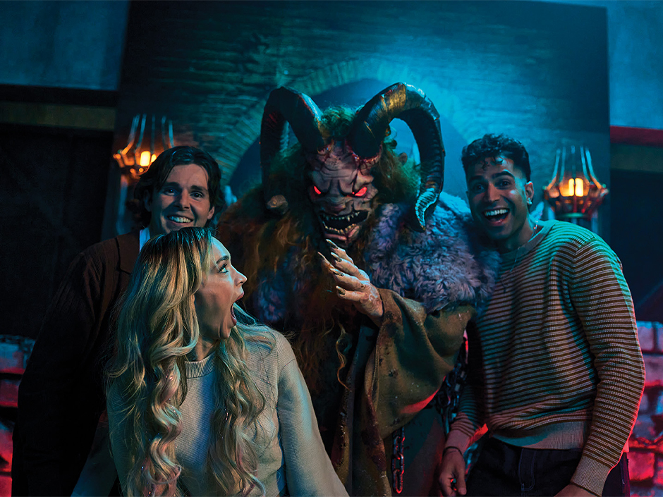Krampus stands between four guests at Universal Horror Unleashed in Las Vegas