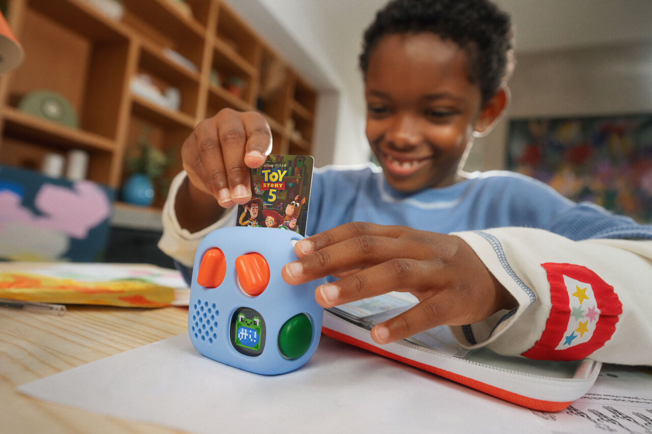 Child inserting the Toy Story 5 audio card into a blue Yoto player
