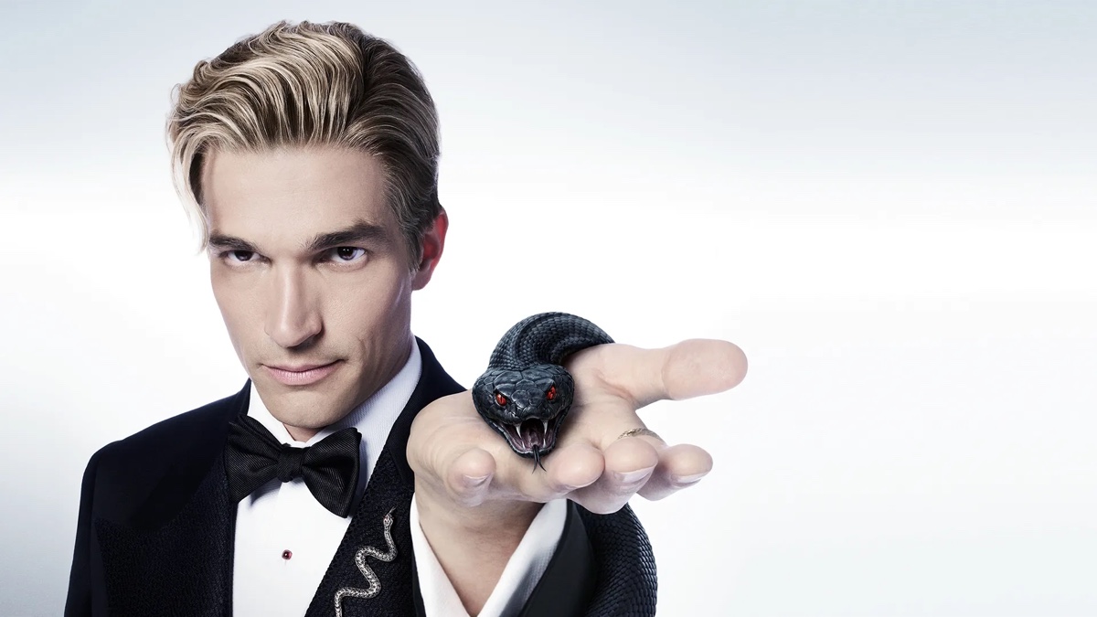 Paul Anthony Kelly poses in a tuxedo with a black snake in American Horror Story: 13 promotional art