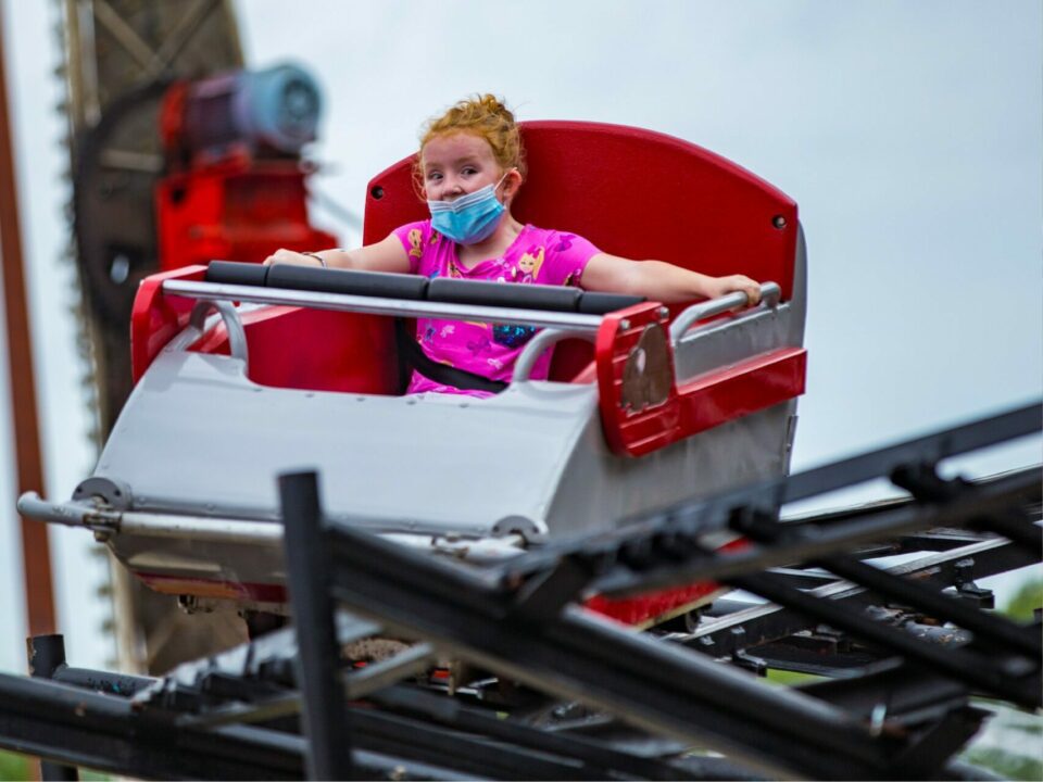Guest riding the red and white Mad Mouse roller coaster at Arnolds Park