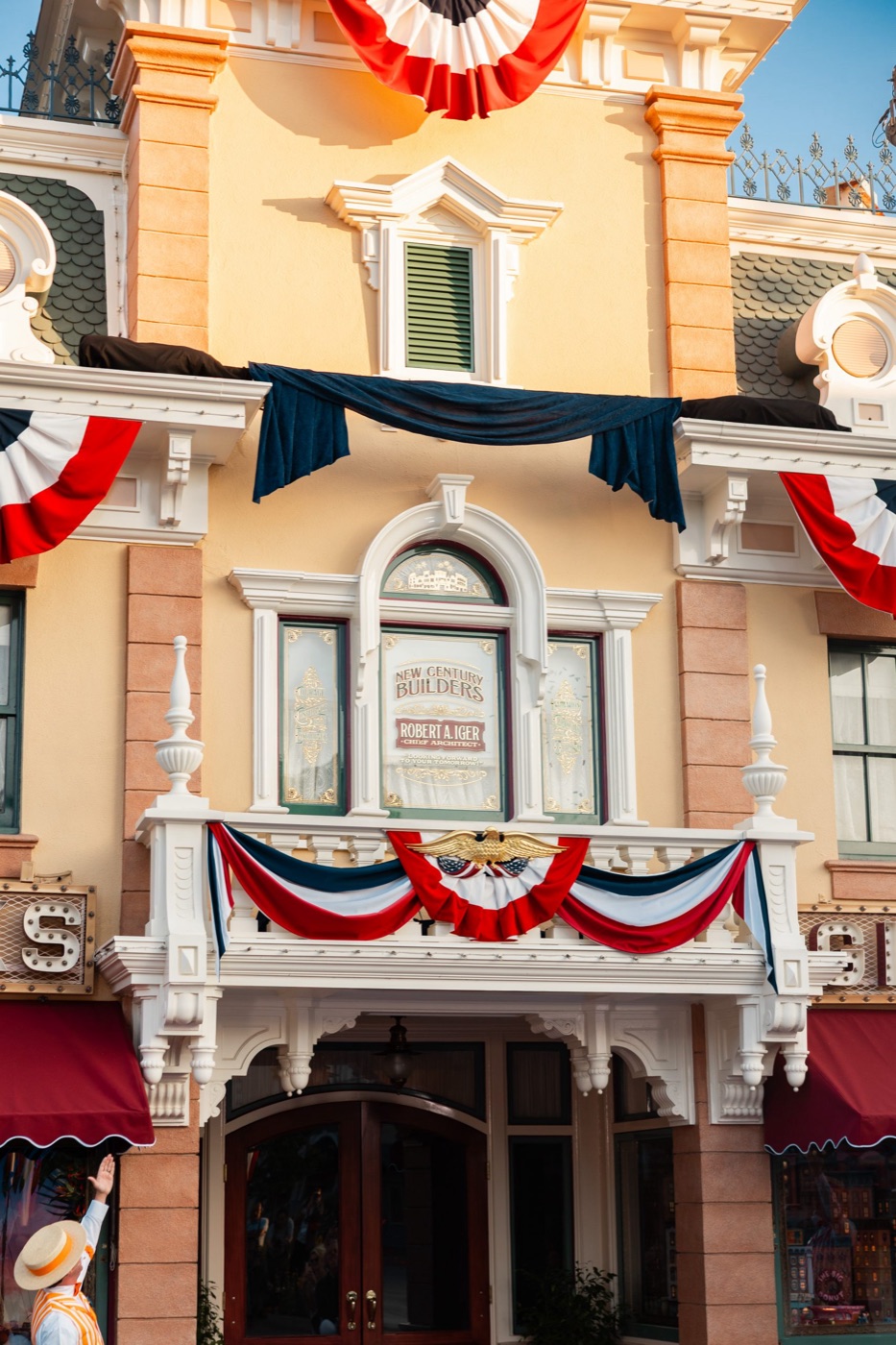 Bob Iger stands beside his framed Disneyland Main Street window design