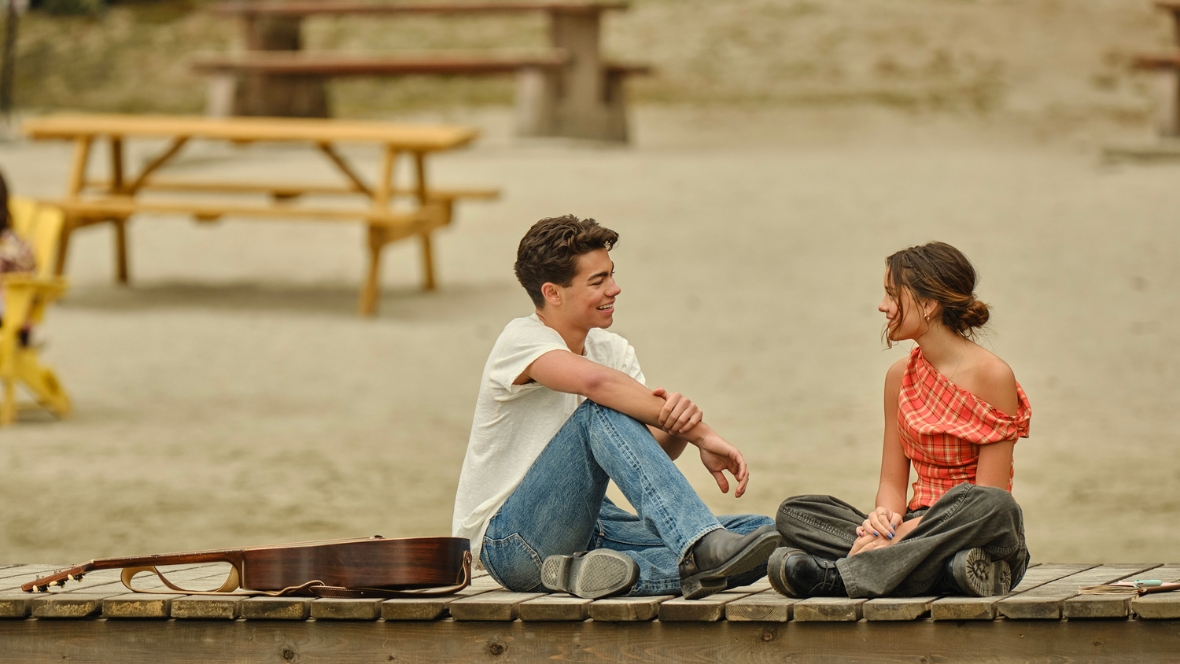 Malachi Barton and Liamani Segura sit together on a dock in Camp Rock 3