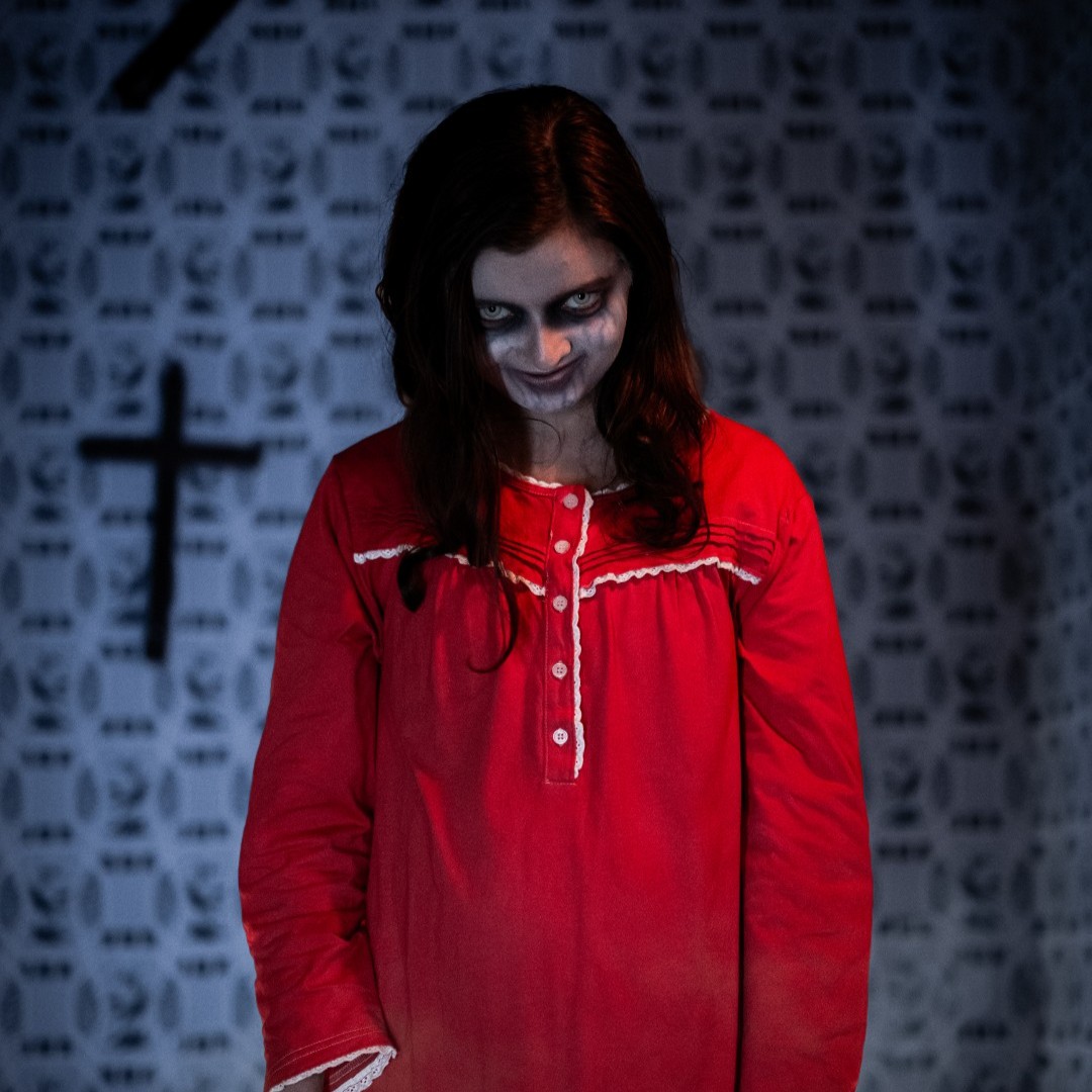 A Conjuring: Beyond Fear character in a red dress at Halloween Haunt