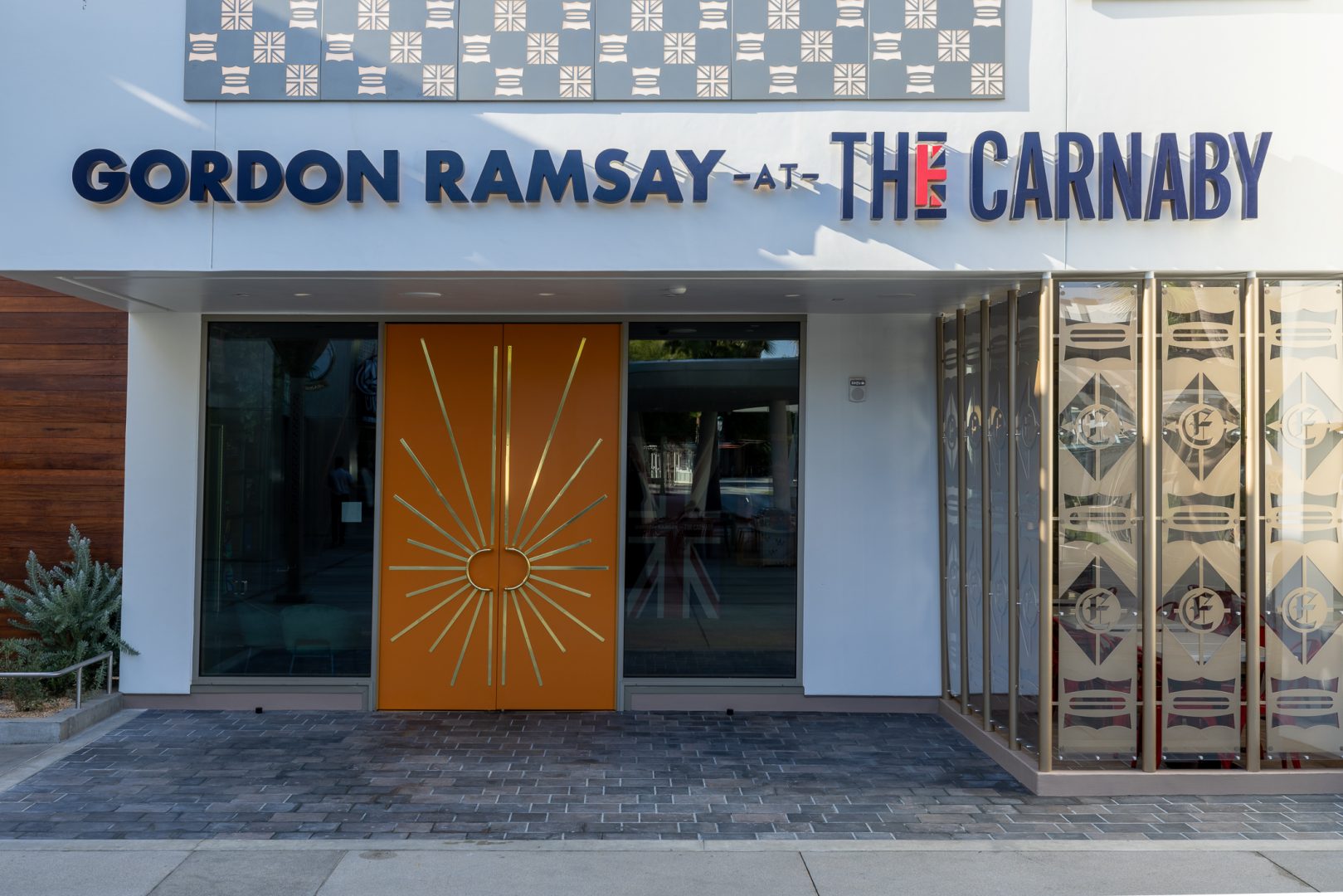 Gordon Ramsay at The Carnaby sign and orange entrance doors