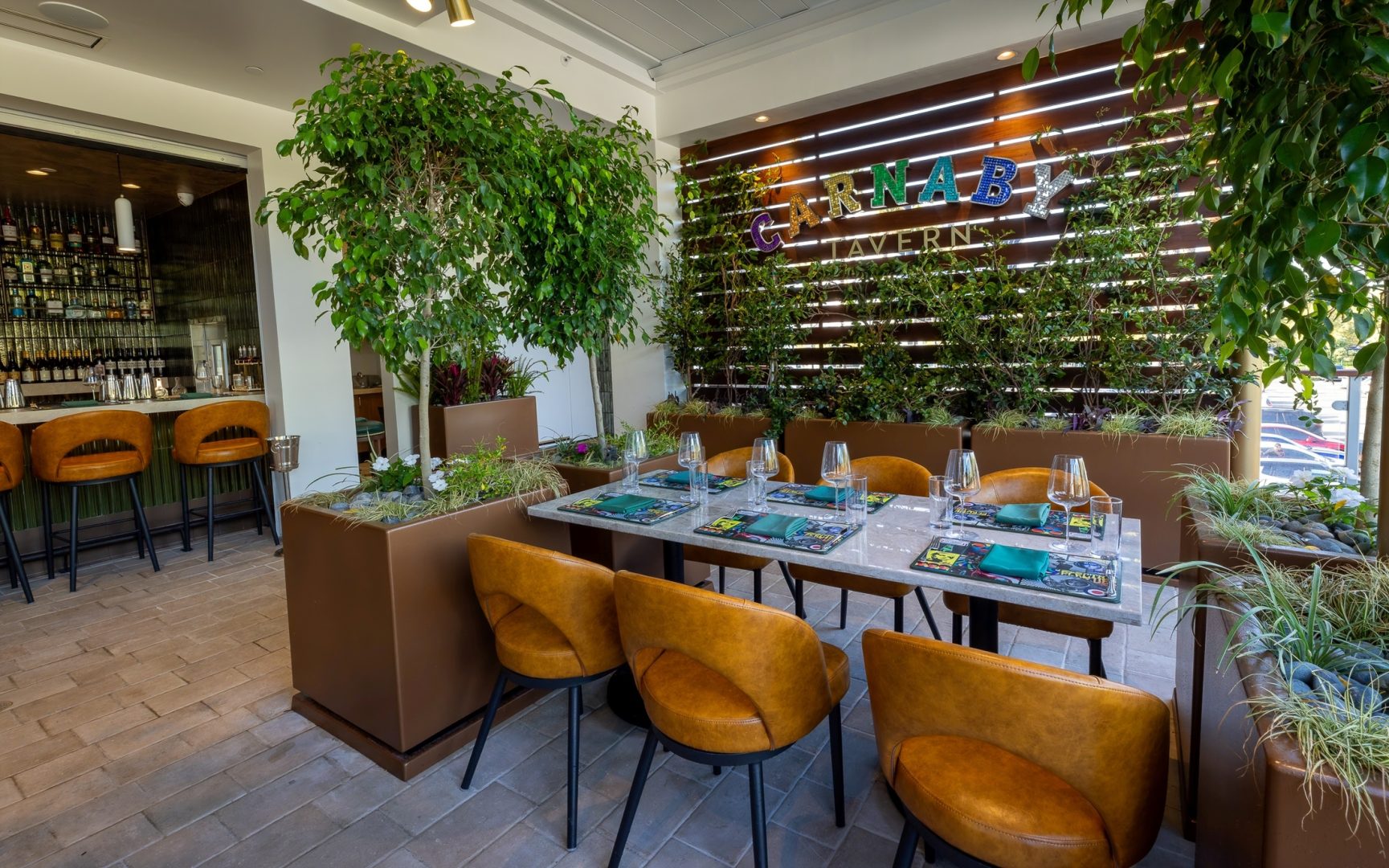 Carnaby Tavern terrace with restaurant sign, tables and bar seating