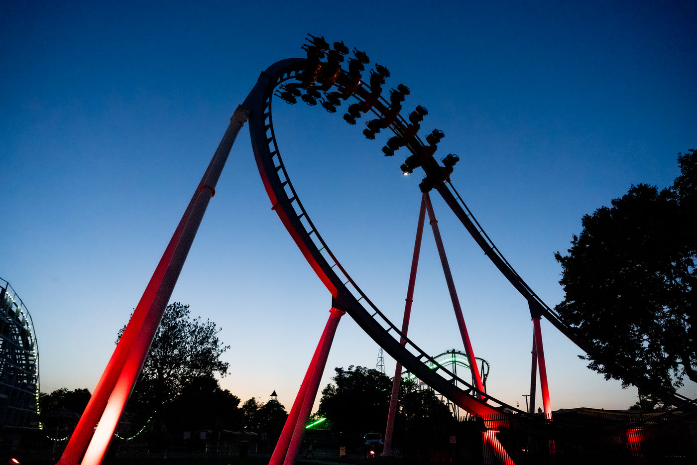 Cedar Point coaster track rises above patriotic event decorations at sunset