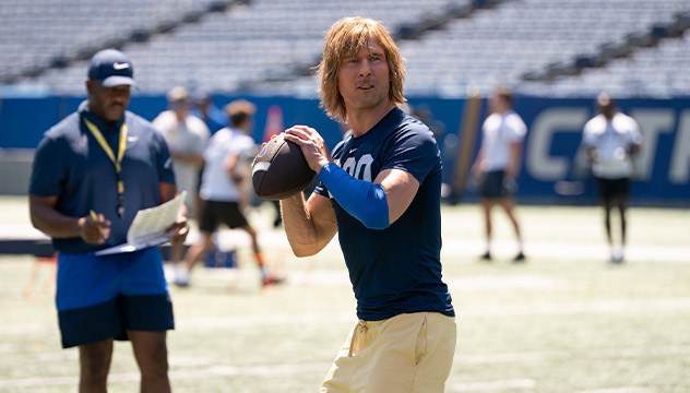 Glen Powell as Chad Powers stands beside teammates on a football practice field