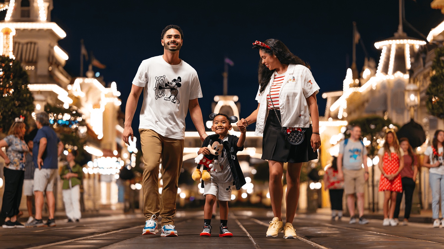 A family walks along Main Street, U.S.A. at Magic Kingdom after dark