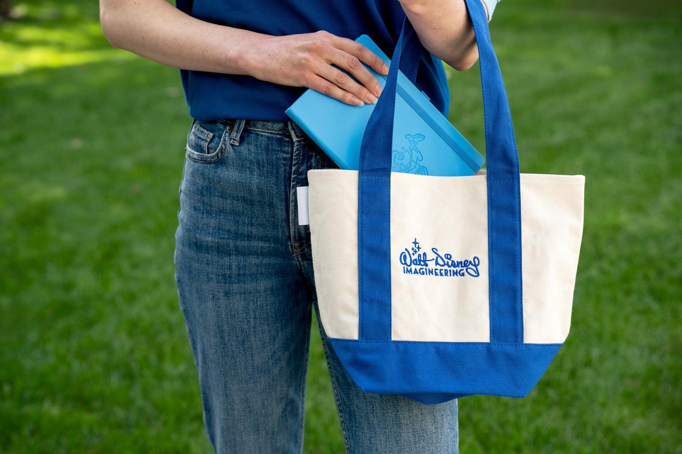 Walt Disney Imagineering tote bag and blue notebook in a Disney Parks merchandise preview