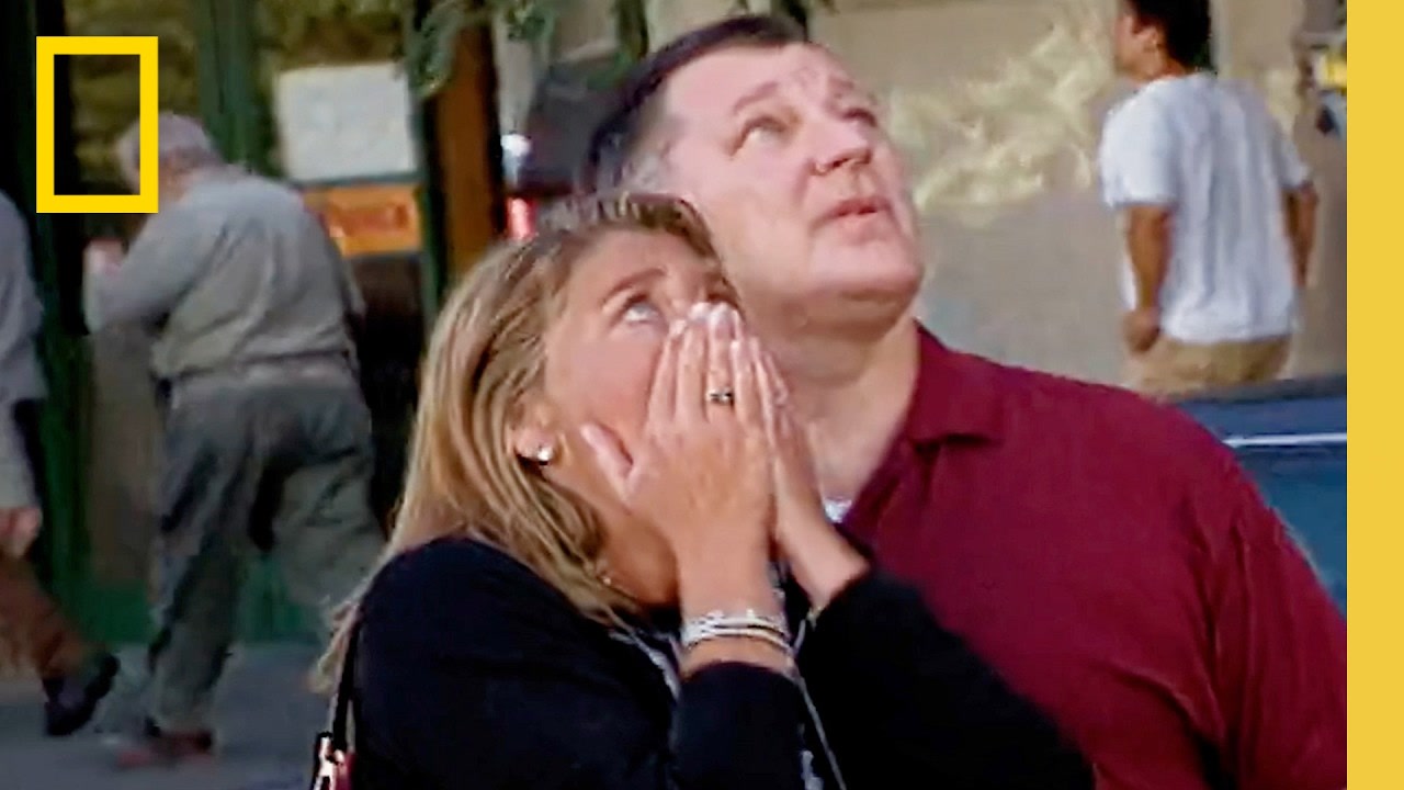 Two people look upward in a National Geographic 9/11 Reunited trailer still