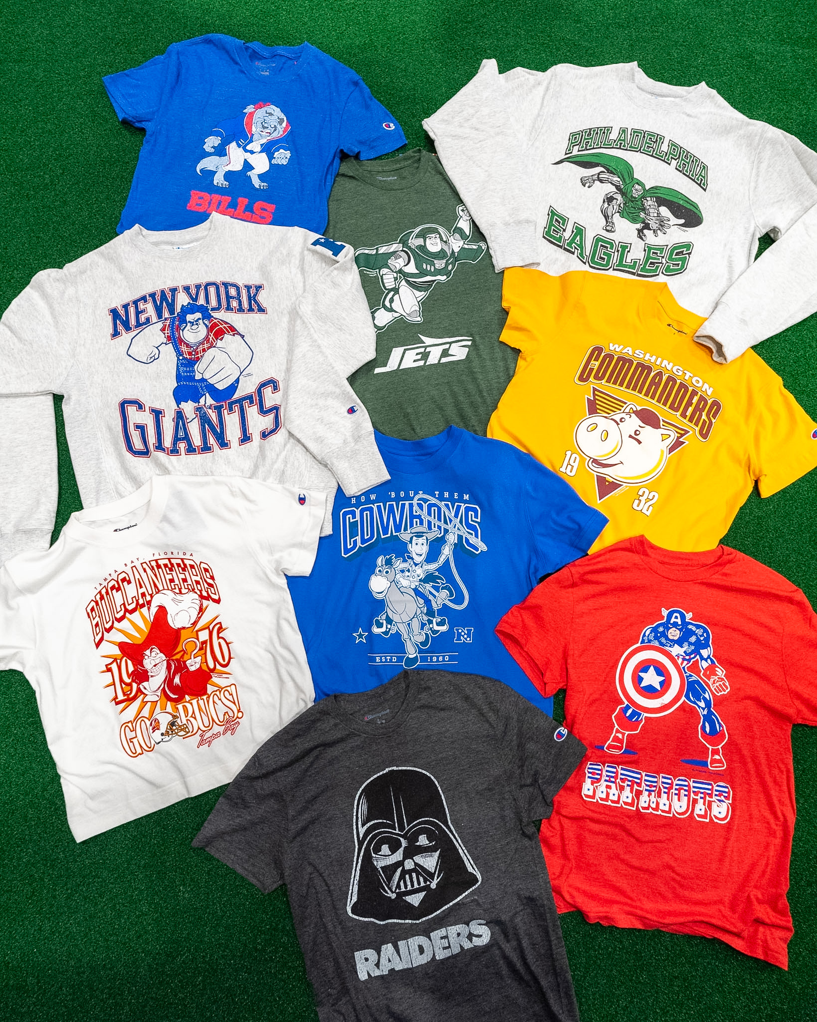 Disney and Champion NFL shirts for several teams arranged on green turf