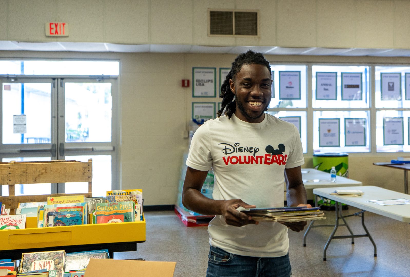 A Disney Programs student carries books at a Florida classroom supply event