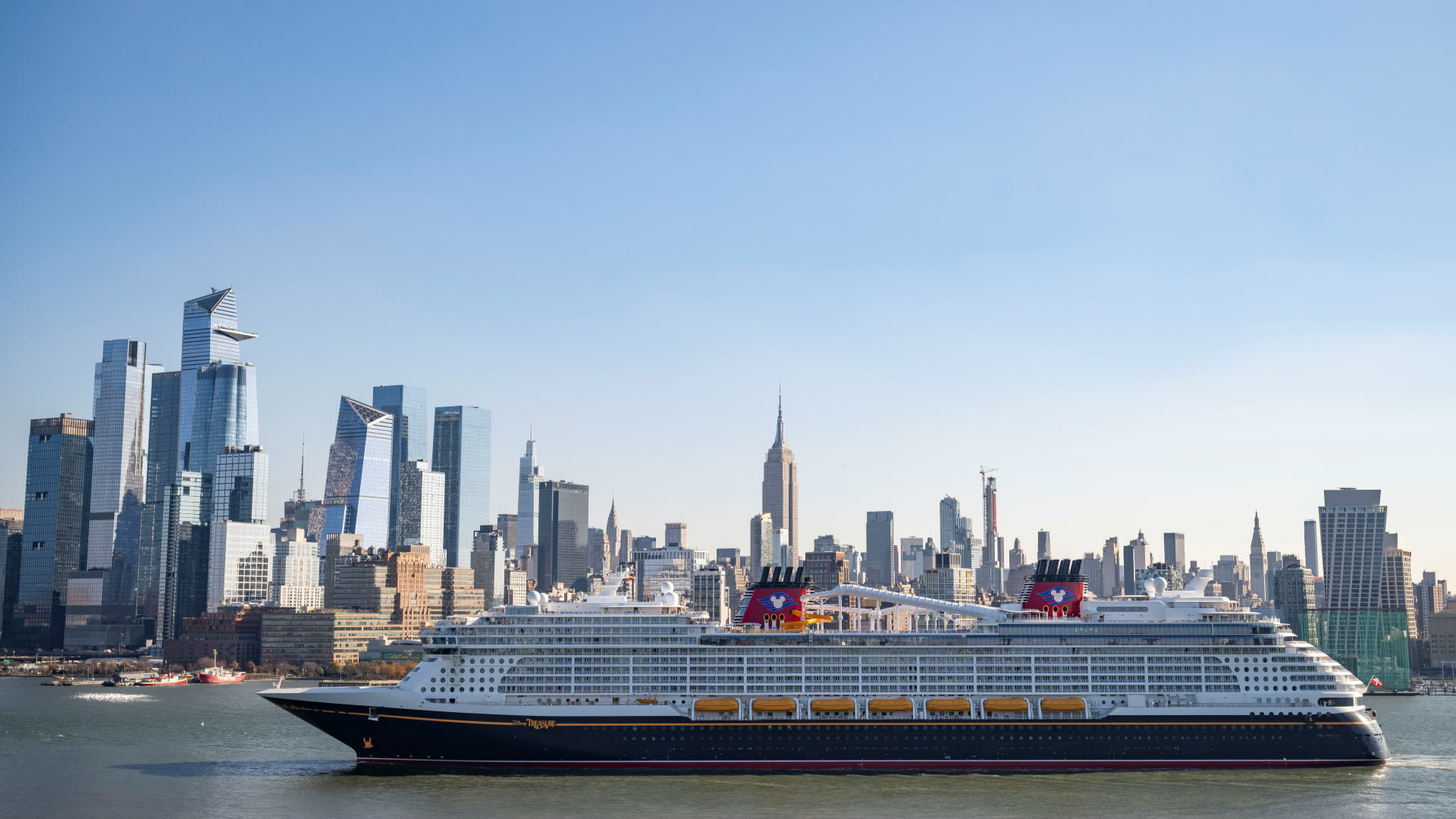Disney Cruise Line ship sailing past the Manhattan skyline in an itinerary announcement image