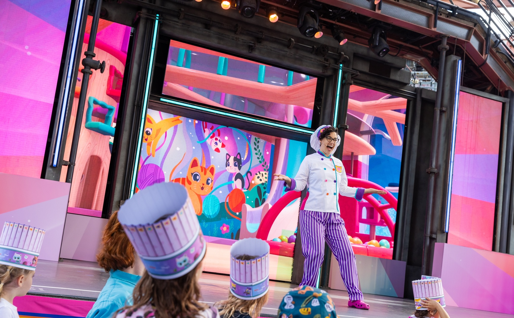 A performer leads a baking activity for children at the Disney Jr. Let's Play Party