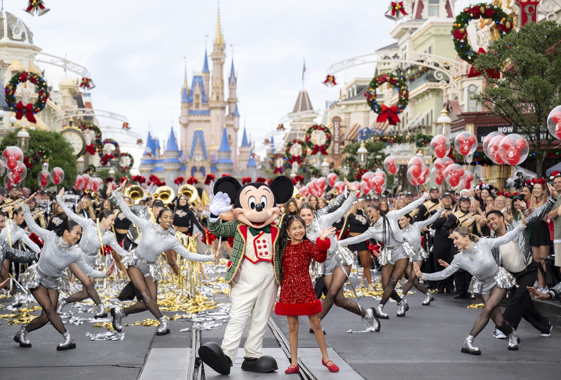 Mickey Mouse and a young performer lead the Disney Parks Christmas parade at Magic Kingdom