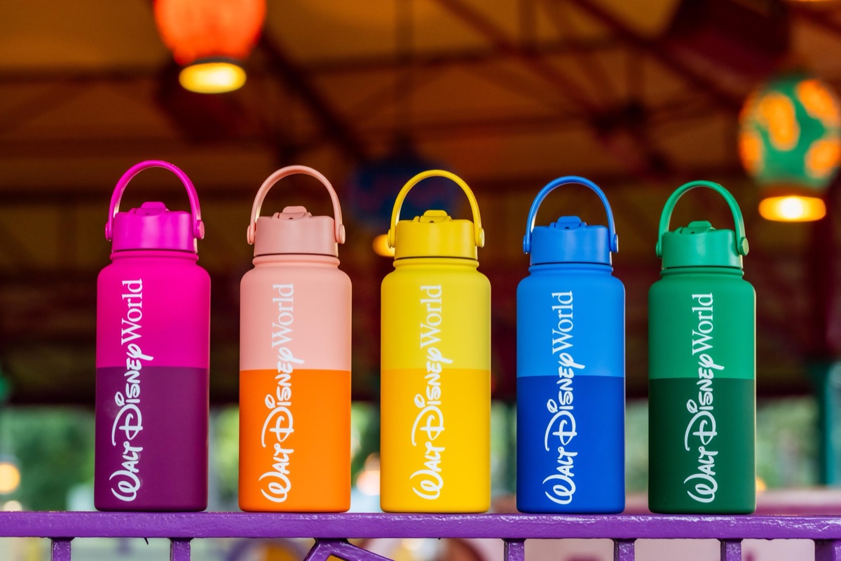 Five Walt Disney World Logo Mania bottles in pink, peach, yellow, blue, and green