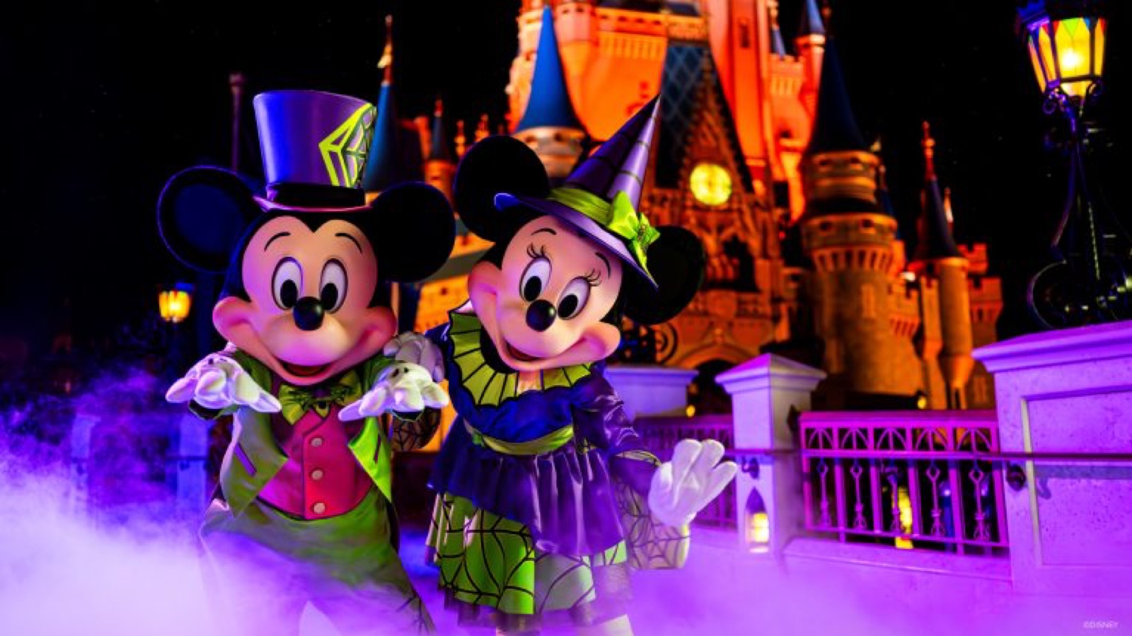 MNSSHP Mickey and Minnie pose in their Halloween outfits in front of Cinderella Castle