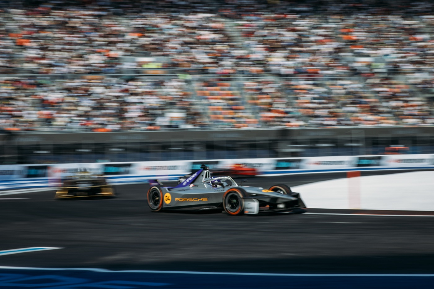 A Formula E race car passes grandstands in Mexico City