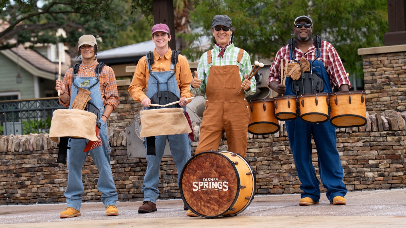 Fall performers pose beneath autumn decorations at Disney Springs