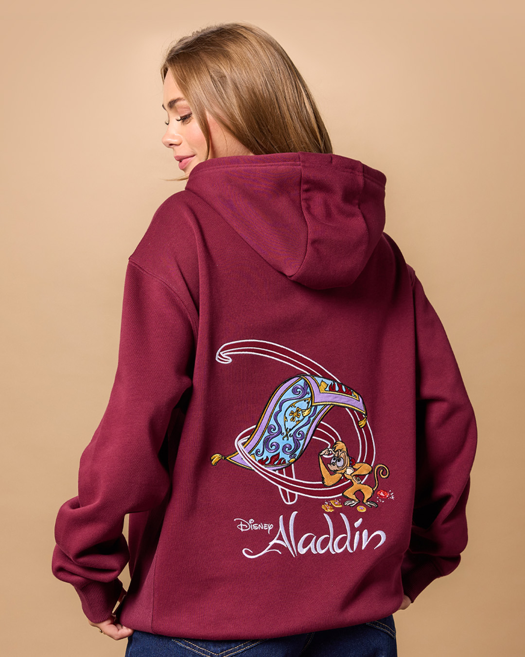 Back of a burgundy Aladdin hoodie embroidered with the Magic Carpet and Abu
