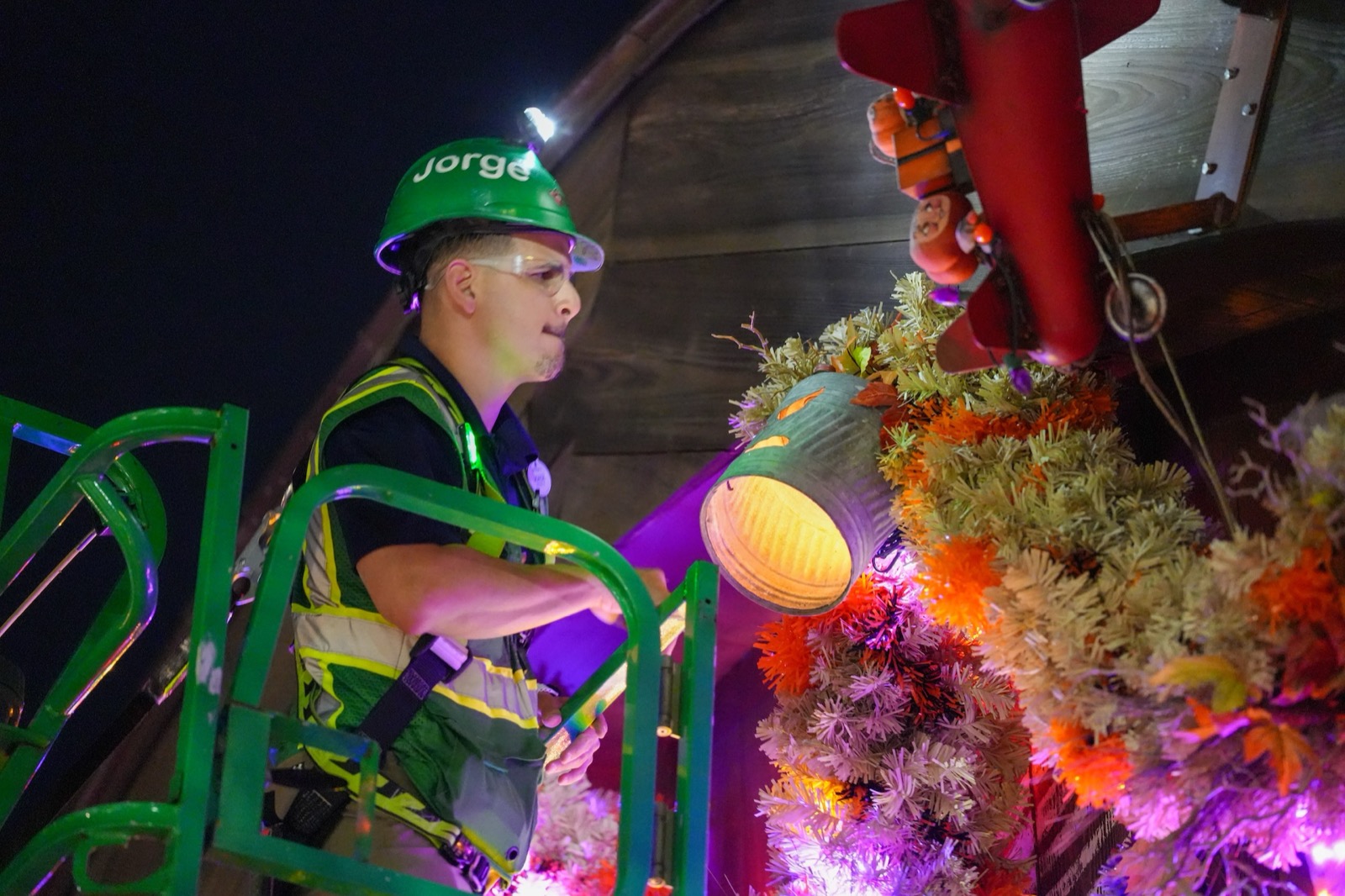 A Disney Holiday Services cast member installs illuminated Halloween garland