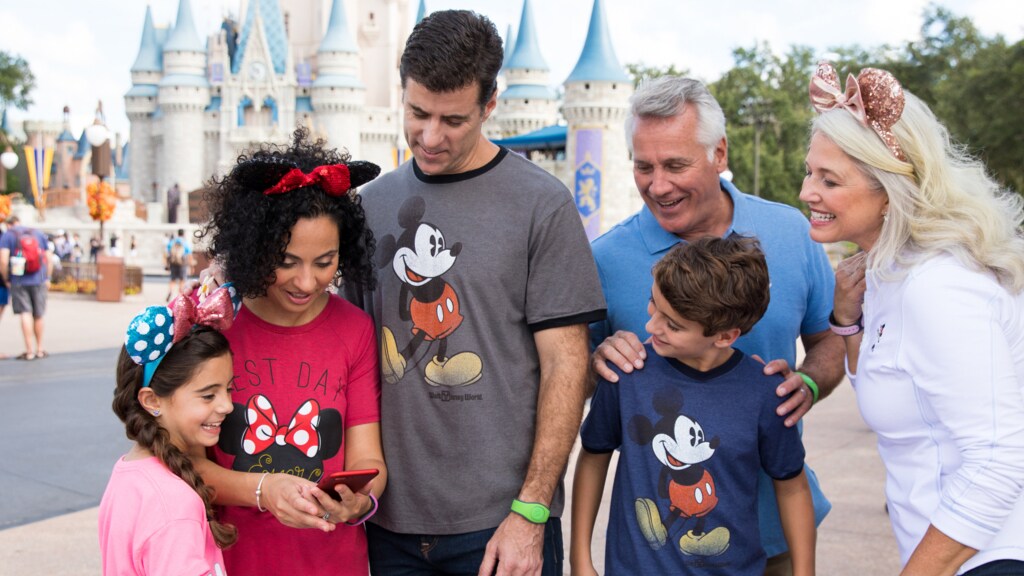 Family using a phone outside Cinderella Castle at Walt Disney World