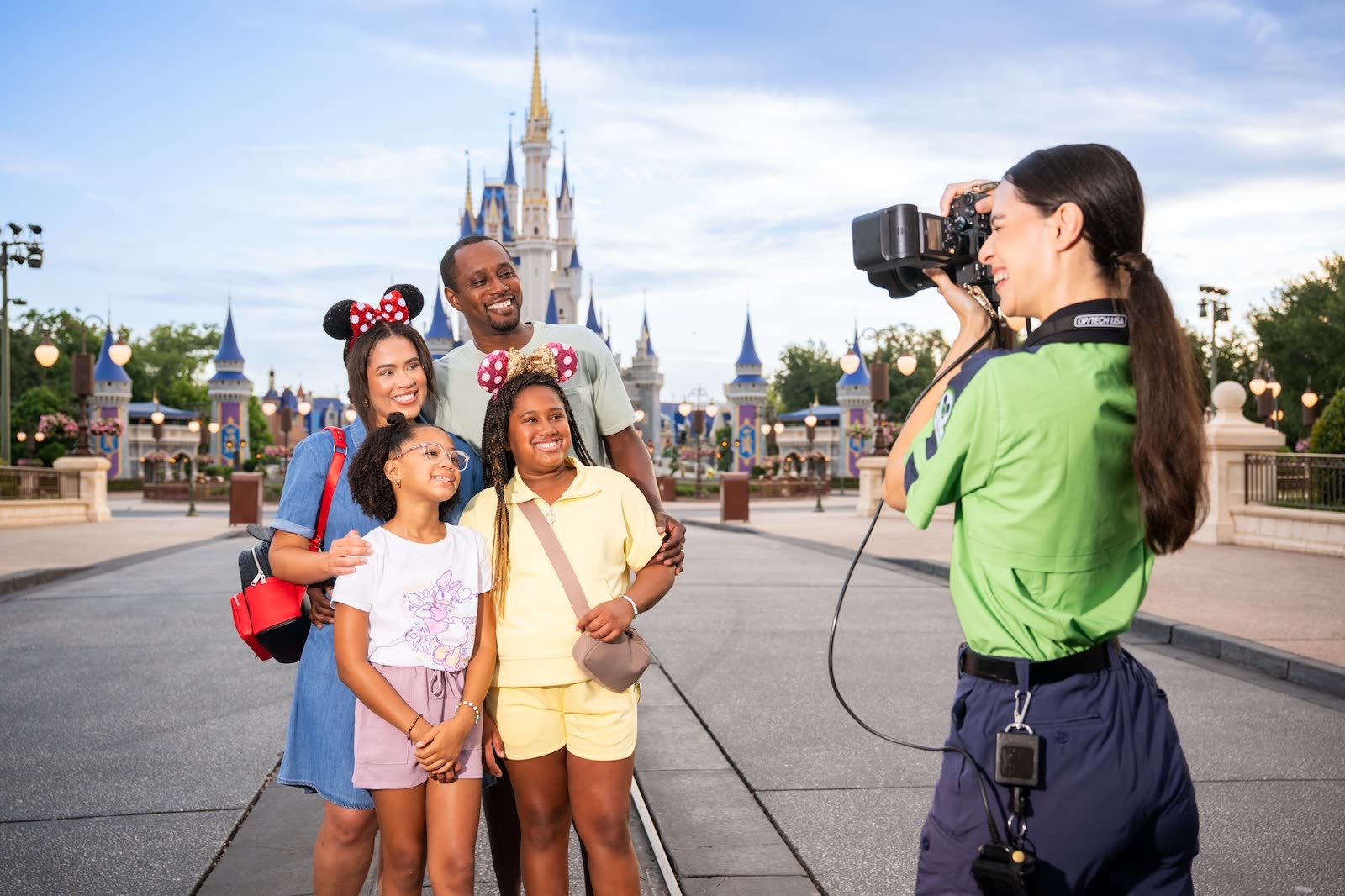 A Disney PhotoPass photographer takes a family photo on Main Street, U.S.A.