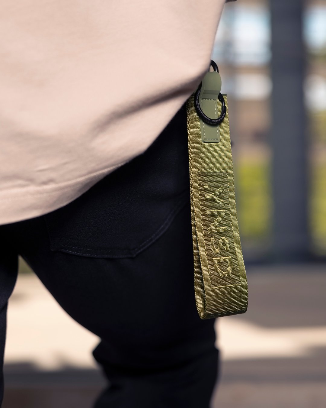 Close view of a green .YNSD apparel strap