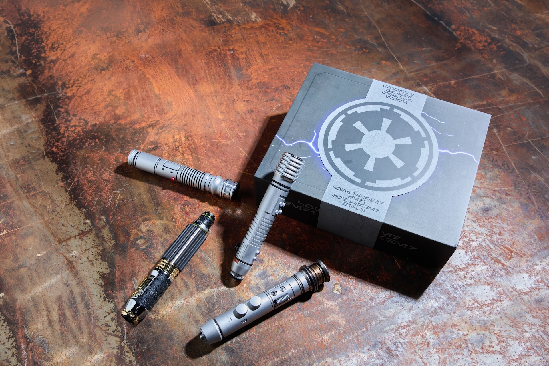 D23 Star Wars legacy lightsaber hilts and display box on a weathered metal table