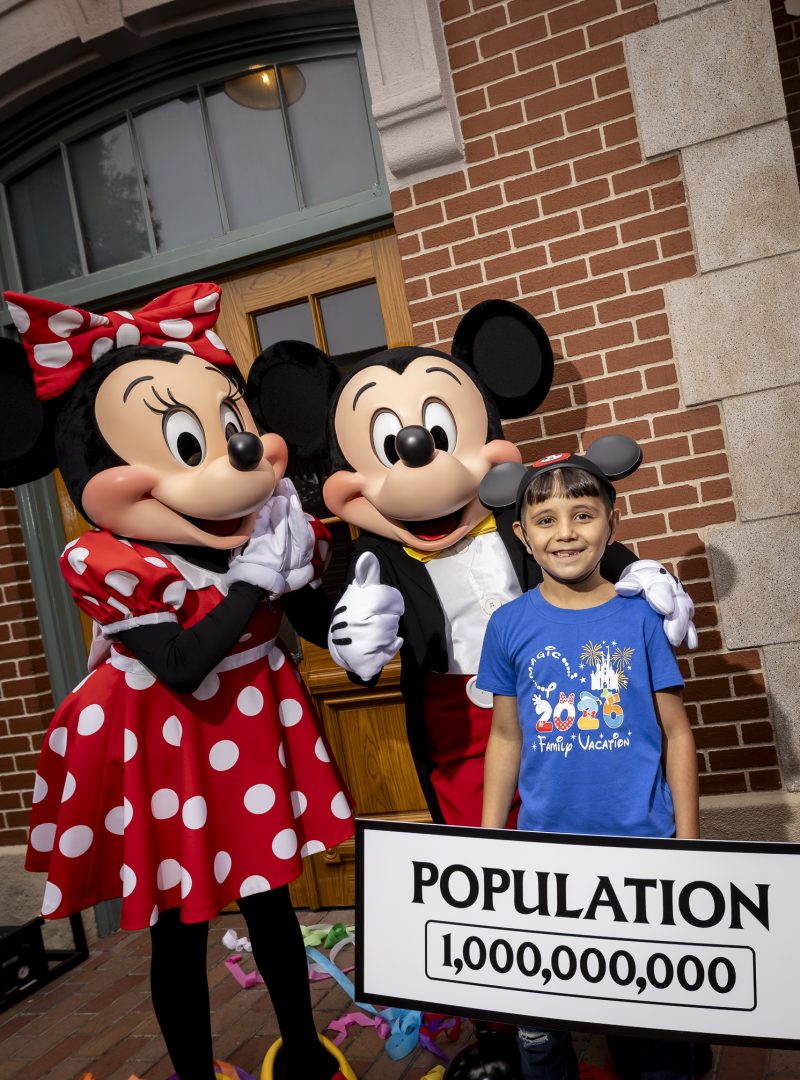 Andres Robles and his parents with Mickey Mouse and Minnie Mouse on the Disneyland train station platform