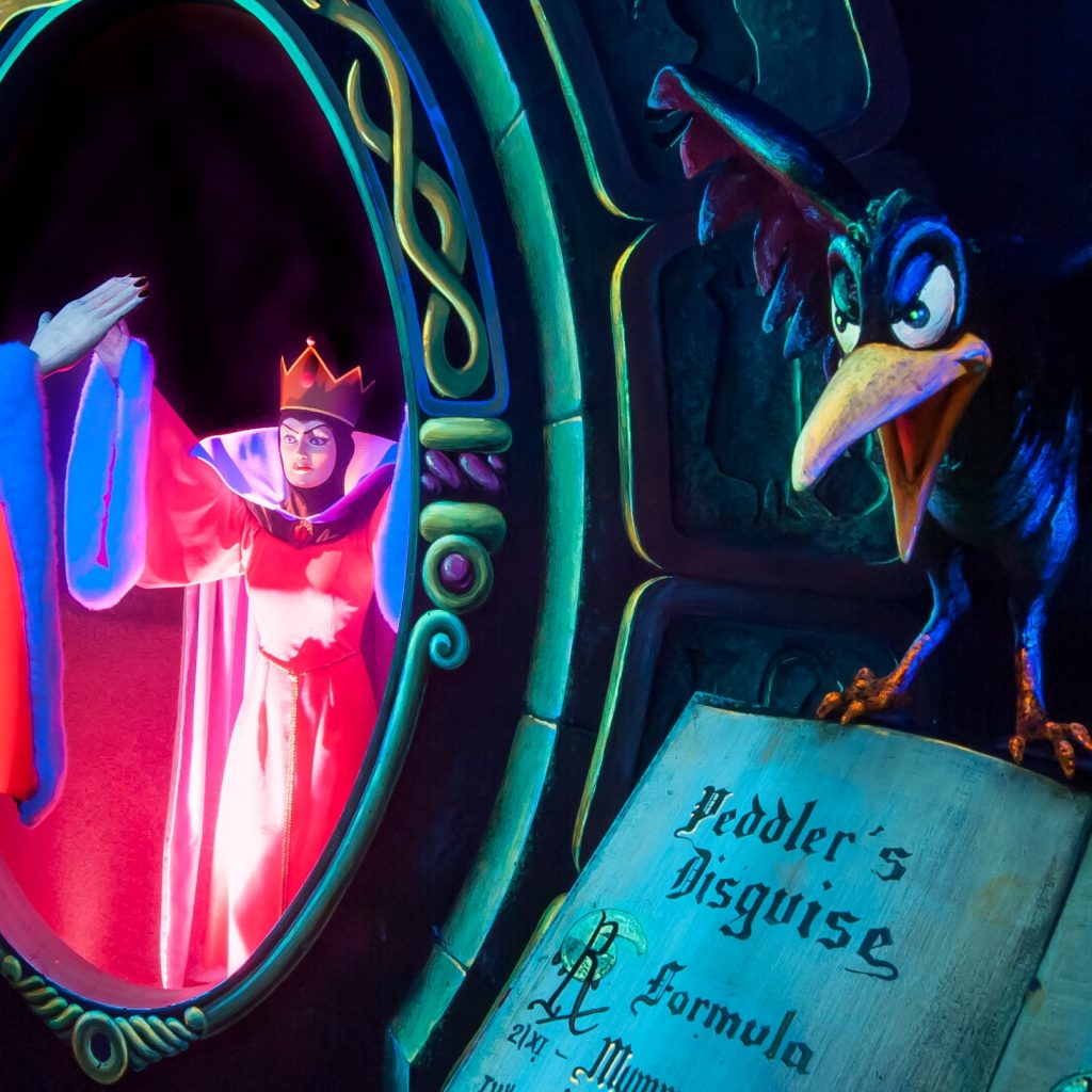 The Evil Queen and her crow beside a poison book inside Blanche-Neige et les Sept Nains