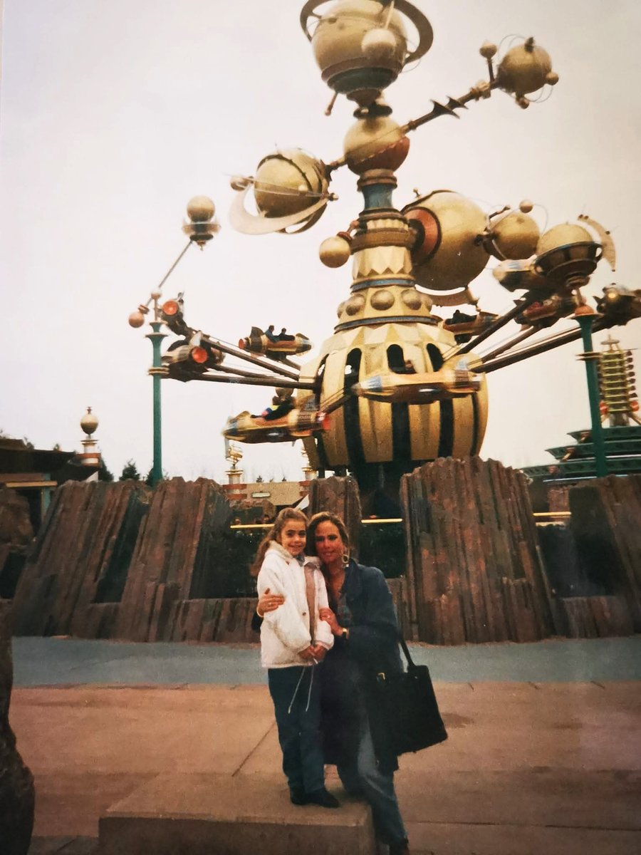 Anne-Lise poses near Orbitron at Disneyland Paris during her first wish visit