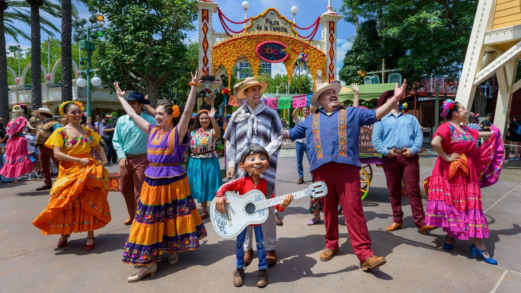 Storytellers performing in front of the Plaza de la Familia Coco arch at Disney California Adventure