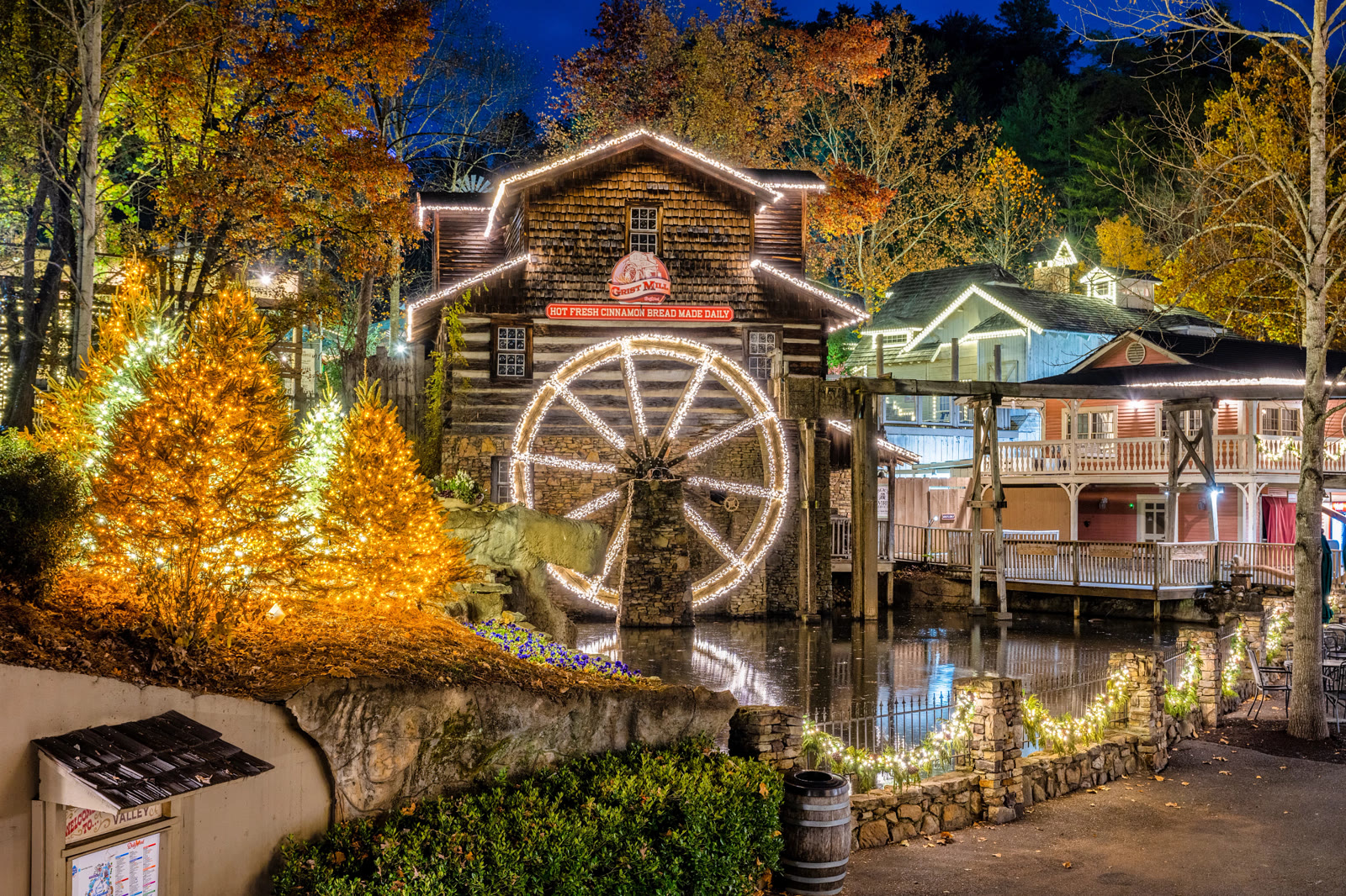 Dollywood's Grist Mill and Christmas trees covered in lights during Smoky Mountain Christmas