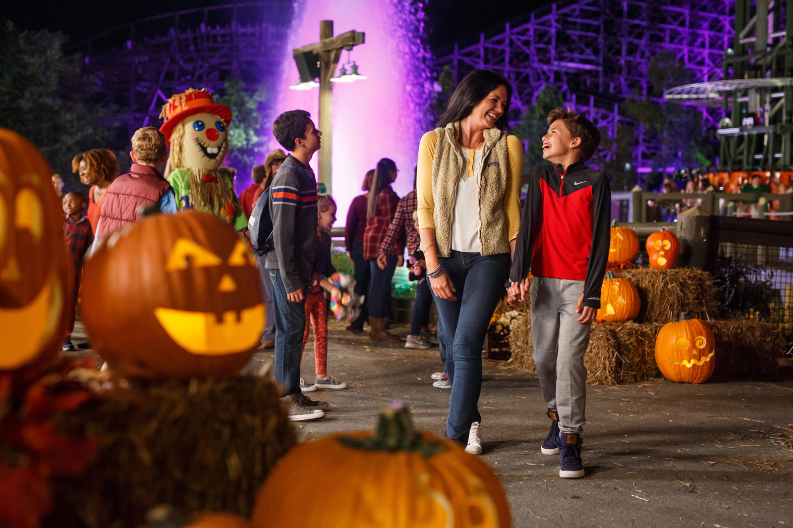 A family walks through Dollywood's glowing Great Pumpkin LumiNights displays