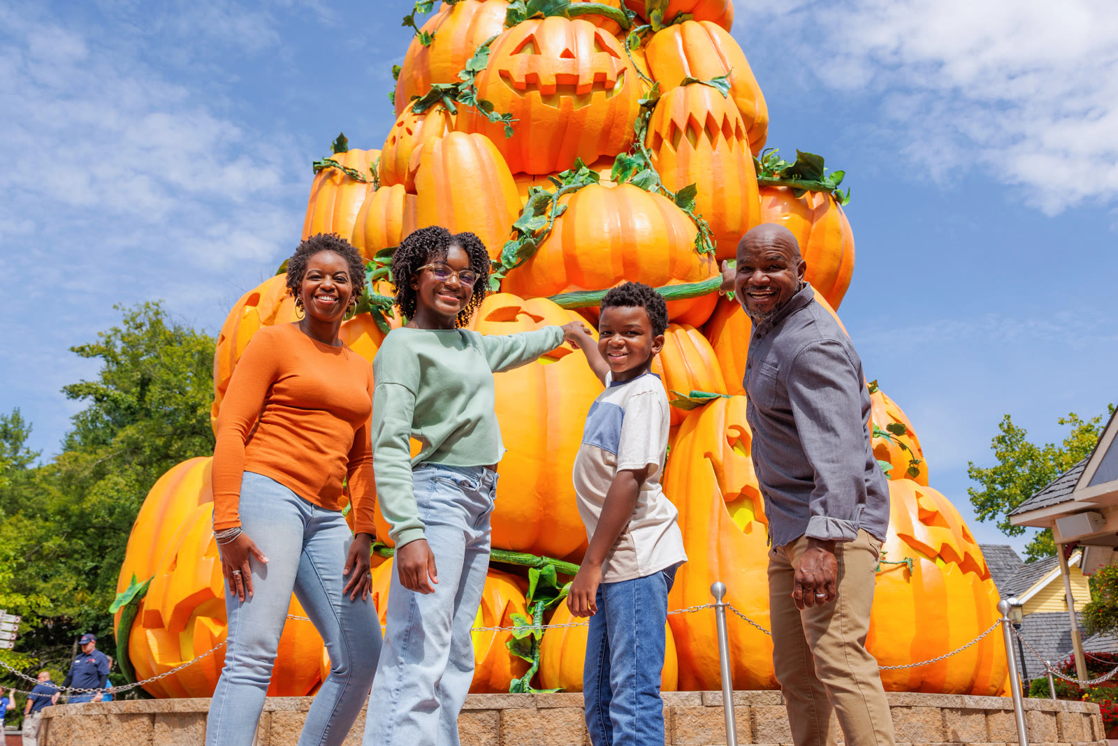 A family poses in front of Dollywood's Great Pumpkin Tree