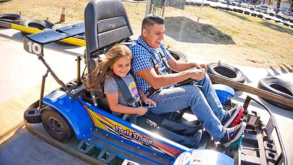 Guests riding a Fiesta Village go-kart on the park's official attraction page
