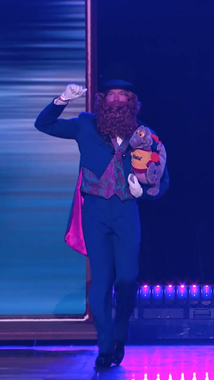 Dreamfinder carrying Figment during the D23 Disney Experiences presentation