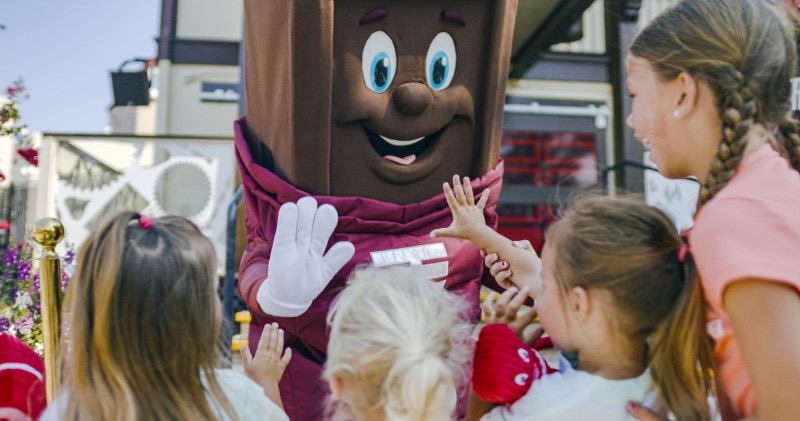 A young guest high-fives a Hersheypark character.