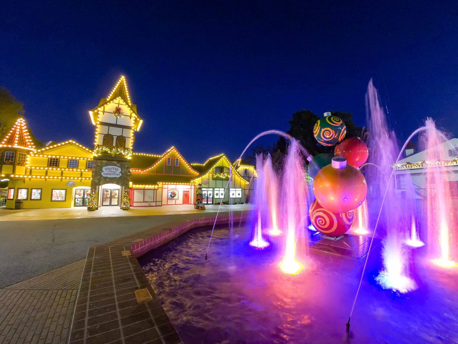 Holiday World buildings, fountains and Christmas decorations lit at night