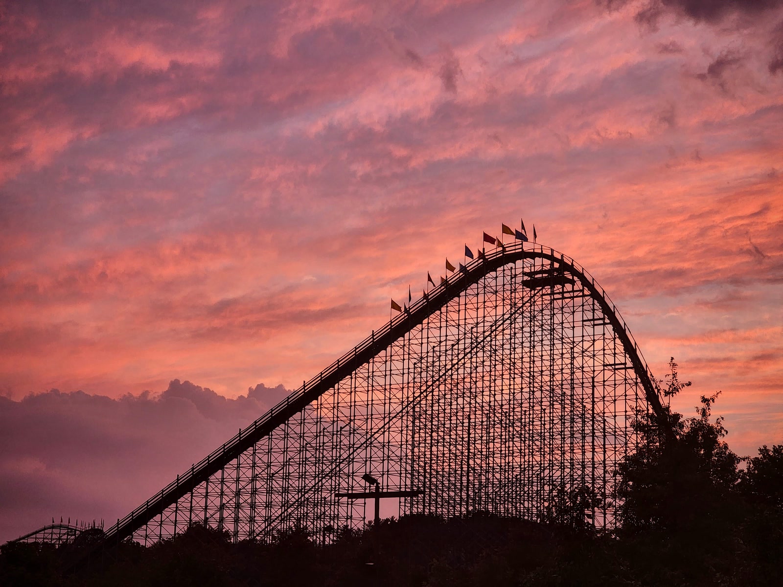 The Voyage roller coaster silhouetted against a pink sunset at Holiday World