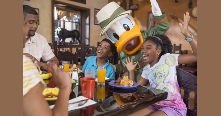 Donald Duck dining with a family at Walt Disney World