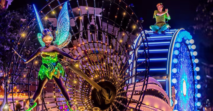 Paint the Night performer on a glowing Disneyland parade float during the 70th Anniversary Celebration