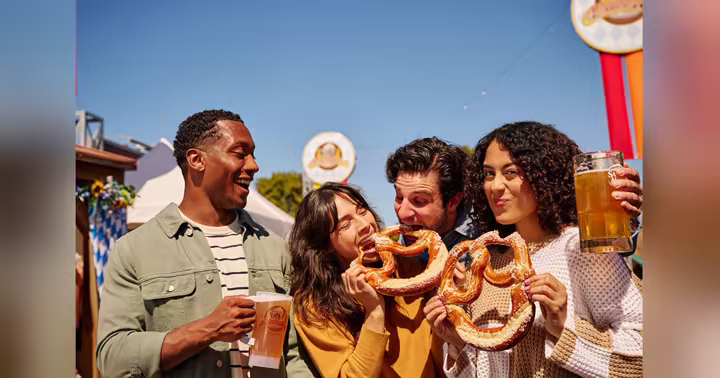 Visitors share pretzels and beer during Oktoberfest at Six Flags Fiesta Texas