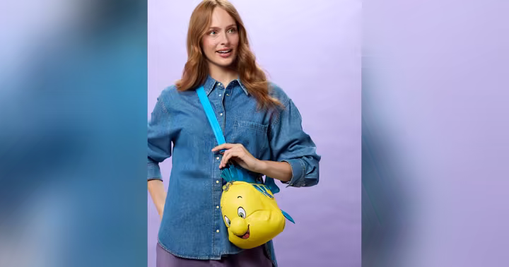 A model wears the Flounder Loungefly crossbody bag from Disney Store