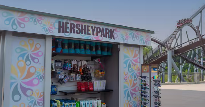 Hersheypark-branded Supply Co. mini-store with merchandise and a roller coaster behind it