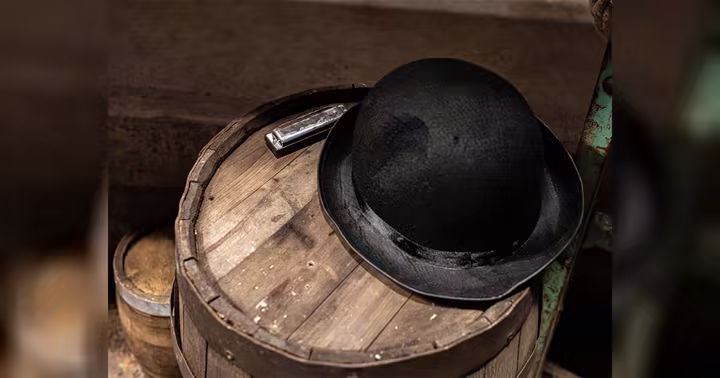 A black hat and harmonica on a barrel inside Universal Orlando's Sinners haunted house