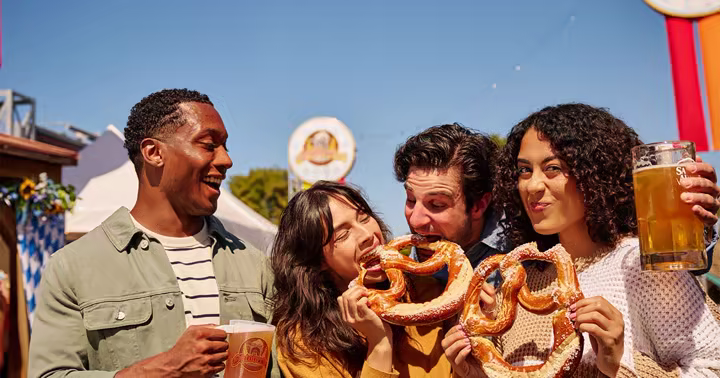 Guests share pretzels and beer during Oktoberfest at Six Flags Over Texas