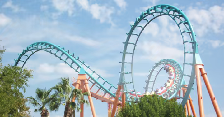Roller coaster track at a Six Flags park beneath a blue sky