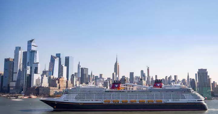 Disney Cruise Line ship sailing past the New York City skyline